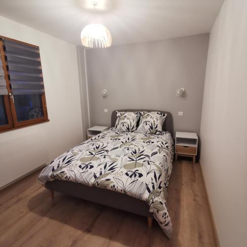 um quarto com uma cama com um edredão preto e branco em Menthon Cœur de village em Menthon-Saint-Bernard