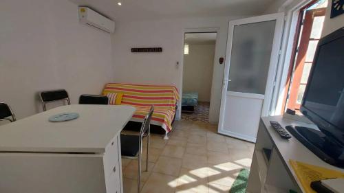 - un salon avec une table, des chaises et une télévision dans l'établissement Fois Pêcheur, à Valras-Plage