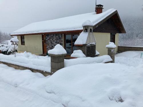 une maison recouverte de neige devant une maison dans l'établissement AU PETIT BONHEUR 