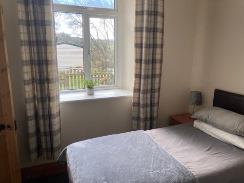 a bedroom with a bed and a window at Station House Self Catering, Catton in Hexham
