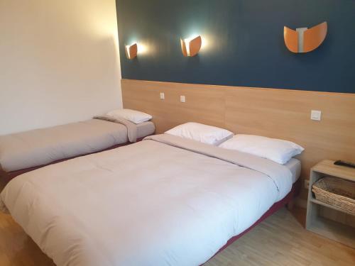 - une chambre avec 2 lits et un mur bleu dans l'établissement Auberge du Couesnon, à Vendel