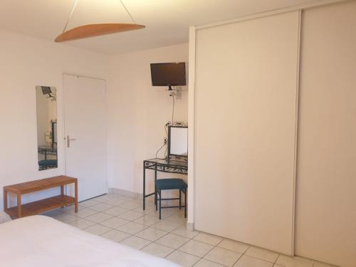 - une chambre avec un lit, un bureau et une télévision dans l'établissement Auberge du Couesnon, à Vendel