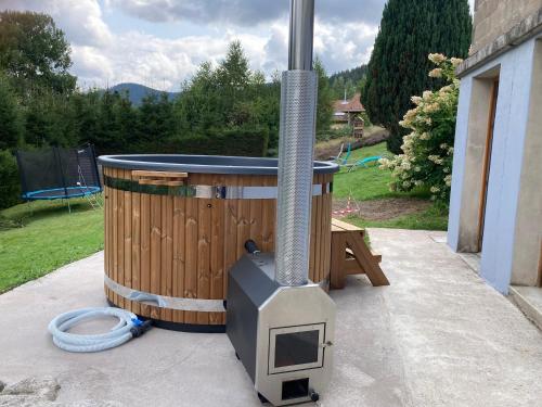 - un barbecue extérieur au feu de bois avec un tonneau dans l'établissement AU PETIT BONHEUR 