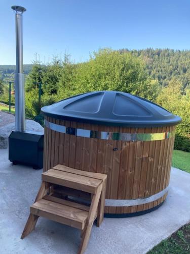 une poubelle en bois avec un banc en bois à côté dans l'établissement AU PETIT BONHEUR 