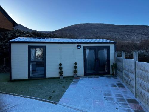 a small white building with a door and a fence at Atlantic Sea View in Tralee