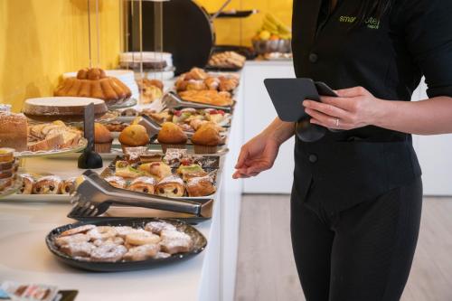 a woman standing in front of a buffet of food at Smart Hotel Napoli in Naples