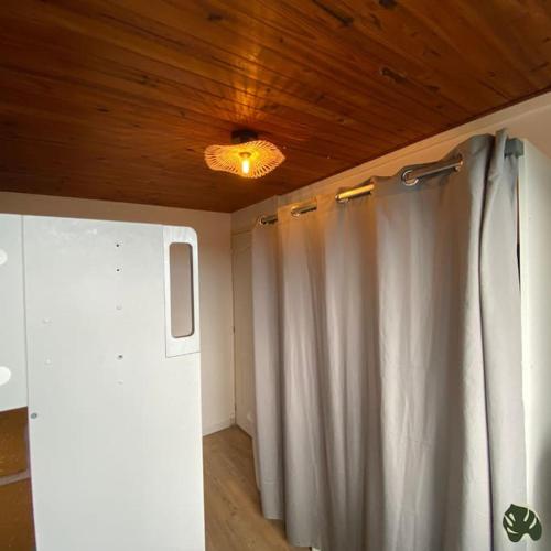 a room with a white shower curtain and a ceiling at La Tit'Kaz Bégonia (Vue montagne) in Saint-Philippe