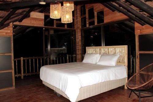 ein Schlafzimmer mit einem weißen Bett in einem Zimmer mit Fenstern in der Unterkunft Letoane@krugerpark in Marloth Park