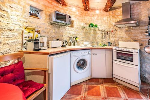 a small kitchen with a washer and dryer at Le Pigeonnier - Piscine - Jardin - Calme in Labastide-de-Lévis
