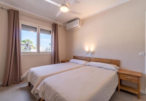 Un dormitorio con una cama grande y una ventana en Apartamento Ponent 1, en Cala Ratjada
