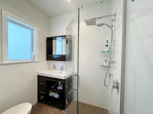 a bathroom with a shower and a sink and a toilet at Charming & Modern 4 BR in Lower Hutt