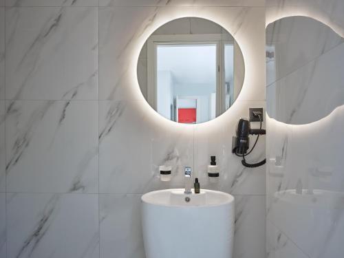 a white bathroom with a sink and a mirror at Athens Project Luxury Apartments in Athens