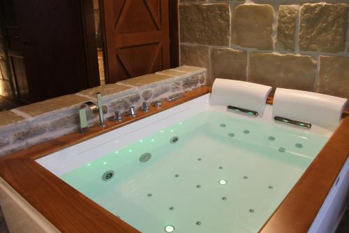 a jacuzzi tub in a bathroom with a stone wall at Pietre di Fiume in Apice