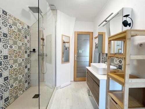 uma casa de banho com um lavatório e um chuveiro em Fenêtres sur mer em Cayeux-sur-Mer