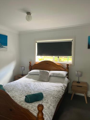 1 dormitorio con 1 cama grande y ventana en Shazzas by the Sea, en Vincentia