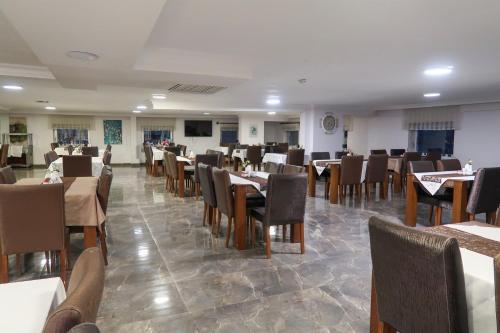Grand Wonne Hotel في أنقرة: غرفة طعام مع طاولات وكراسي في مطعم