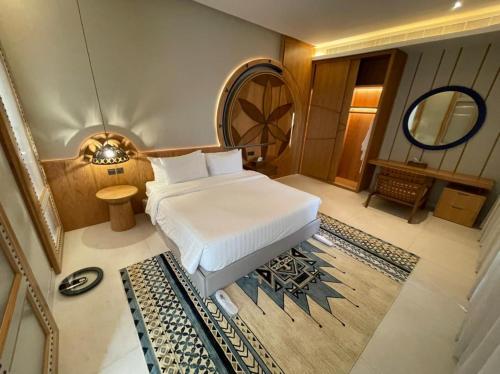 a bedroom with a white bed and a mirror at Aseel Resort in Riyadh