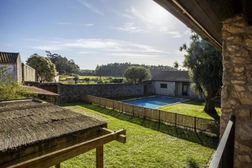 a backyard with a swimming pool and a fence at Alma Peregrina - Casas de Campo in Junqueira