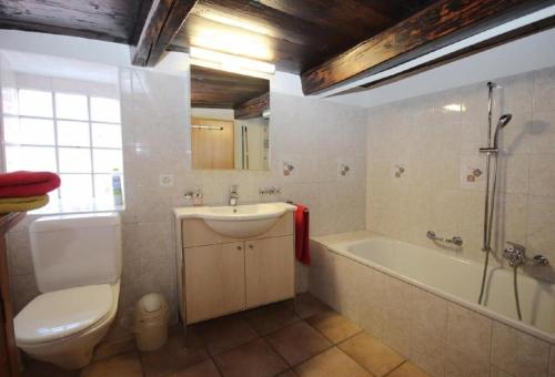 a bathroom with a sink and a tub and a toilet at Ferienhaus "Bella Vista" in Lottigna mit grossem Umschwung, Pergola, Grill und Pizzaofen in Lottigna