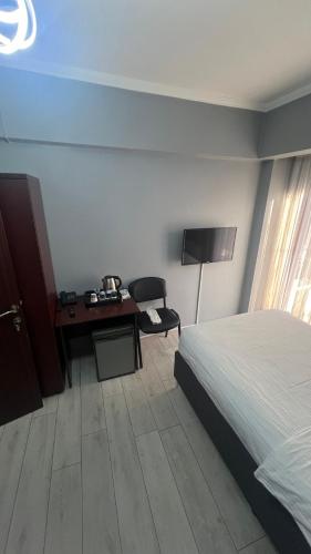 a bedroom with a bed and a desk and a chair at Hotel Ipekyolu in Sapanca