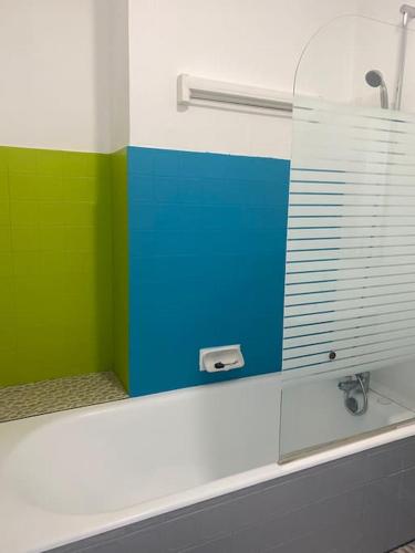 La salle de bains est pourvue d'un miroir vert et bleu. dans l'établissement Appartement*Centre historique*Parking*Terrasse, à Sarlat-la-Canéda