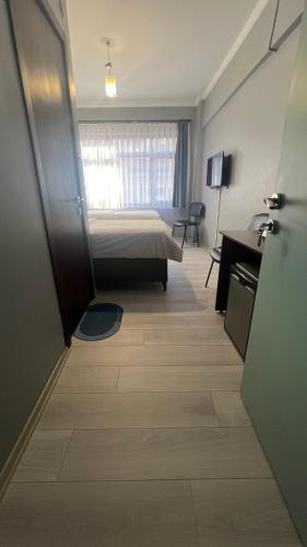 a hotel room with a bed and a desk and a door at Hotel Ipekyolu in Sapanca