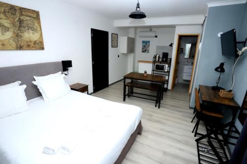 ein Schlafzimmer mit einem Bett und einem Schreibtisch sowie eine Küche in der Unterkunft Apparts' hôtel Casa di a Restonica in Corte