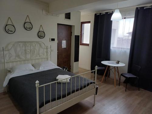 1 dormitorio con cama, mesa y ventana en Tom's House, en Otopeni