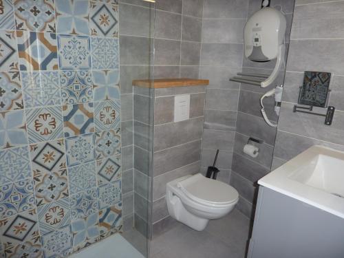 y baño con aseo y lavamanos. en Apparts' hôtel Casa di a Restonica, en Corte