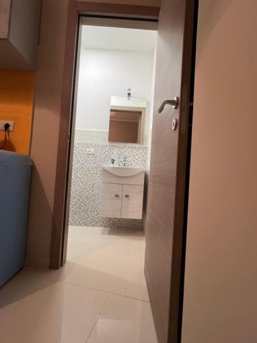 una puerta abierta a un baño con lavabo en Tavernetta Cortile Dalmazia, en Catania