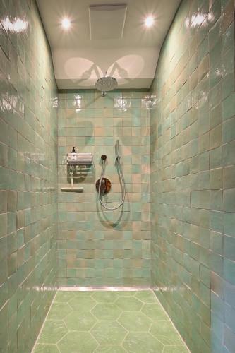 a bathroom with a shower with green tiles at Voglen 2 in Nesselwang