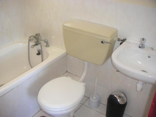Un baño blanco con inodoro y lavabo. en Waterside Living CL07, en Jeffreys Bay