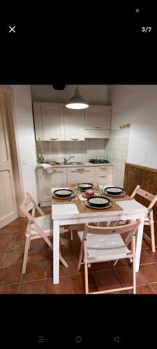 een keuken met een witte tafel en stoelen en een tafel en een stoeltje bij Castelvecchio 168 in Sarnano