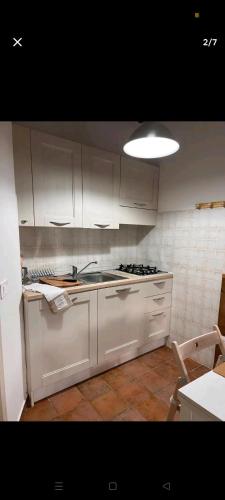 una cucina con armadi bianchi e lavandino di Castelvecchio 168 a Sarnano