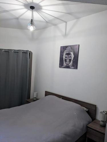 a bedroom with a bed and a picture of a mask at Le Cocon de la Cathédrale in Metz