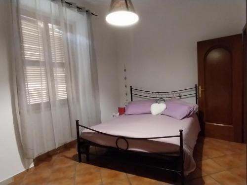 ローマにあるCasa di Lauraのベッドルーム(紫色の枕が付くベッド付)