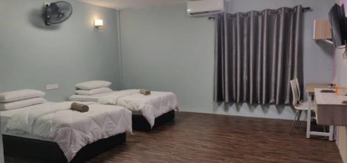 Pokój szpitalny z dwoma łóżkami i telewizorem w obiekcie Tazrah roomstay (1 queen or 2 twin super single room) w mieście Kuala Rompin