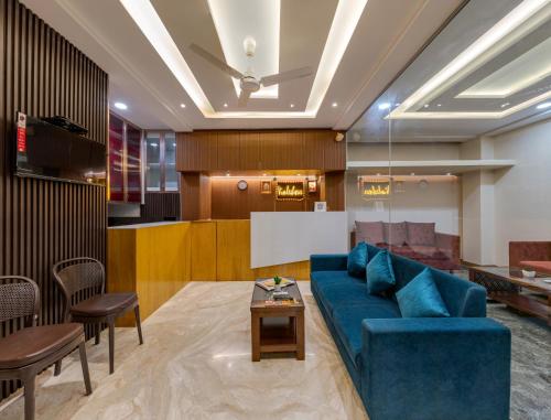 戈爾哈布爾的住宿－Hotel Vimleshwar，客厅配有蓝色的沙发和桌子