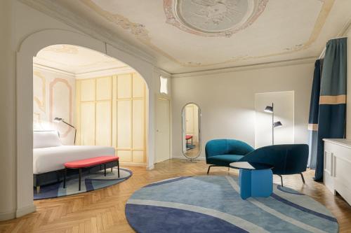 a bedroom with a bed and a table and chairs at Palazzo Dei Fiori by Room Mate in Venice