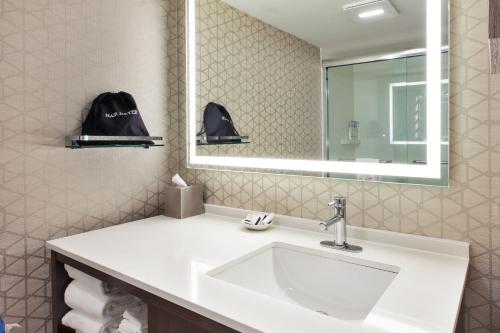 a bathroom with a sink and a mirror at Holiday Inn Va Beach-Oceanside 21st St, an IHG Hotel in Virginia Beach