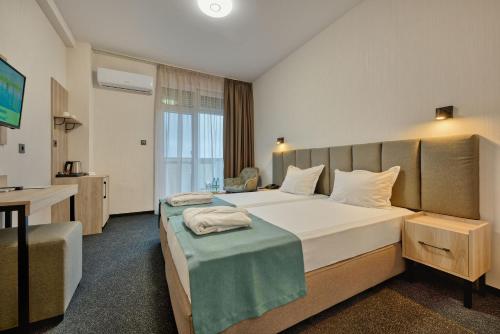 a hotel room with two beds and a television at Augusta SPA Hotel in Hisarya