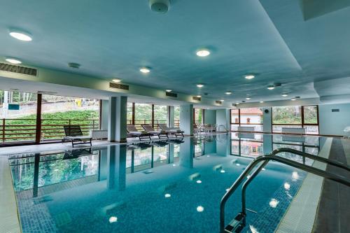 a large swimming pool with chairs in a building at Musala Hotel in Borovets