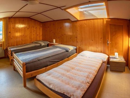 a bedroom with three beds in a boat at 3-Zi-FeWo Gehrihornblick in Frutigen