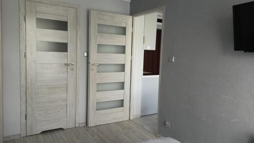 een kamer met twee houten kastdeuren in een kamer bij APARTAMENT USTROŃ 84 in Ustroń
