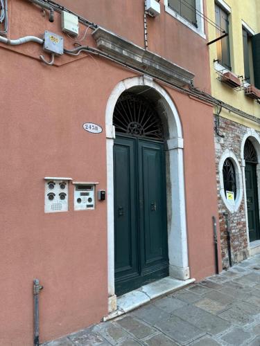 an entrance to a building with a green door at Ca Penini - canal view in Venice