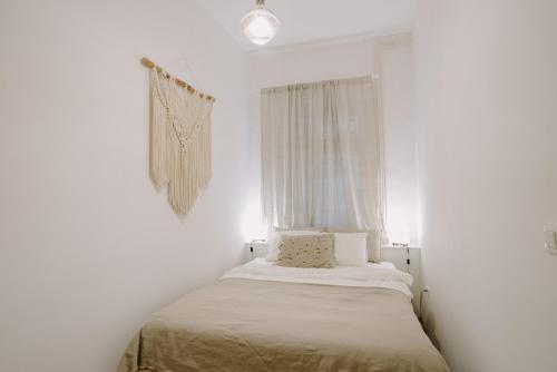 Bett in einem weißen Zimmer mit Fenster in der Unterkunft LUCCA in Zagreb