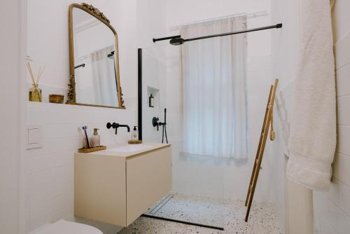 ein weißes Badezimmer mit einem Waschbecken und einem Spiegel in der Unterkunft LUCCA in Zagreb