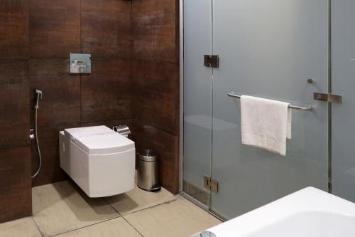 a bathroom with a toilet and a glass shower at Grand Kailash Hotel in Aurangabad