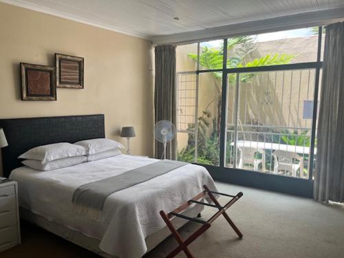 1 dormitorio con cama y ventana grande en Always Here for you, en Krugersdorp