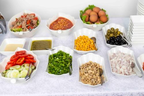a table topped with bowls of different types of food at San Marino Hotel in Accra
